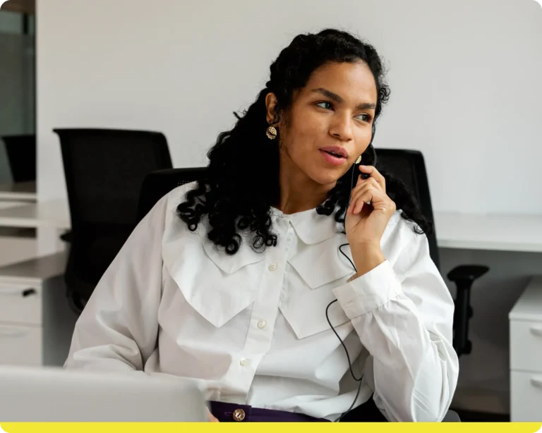 Woman in white shirt talking on headphones